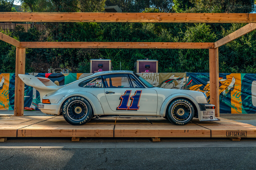 White Porsche 930 Turbo with the number 11 in blue with orange trim on the door