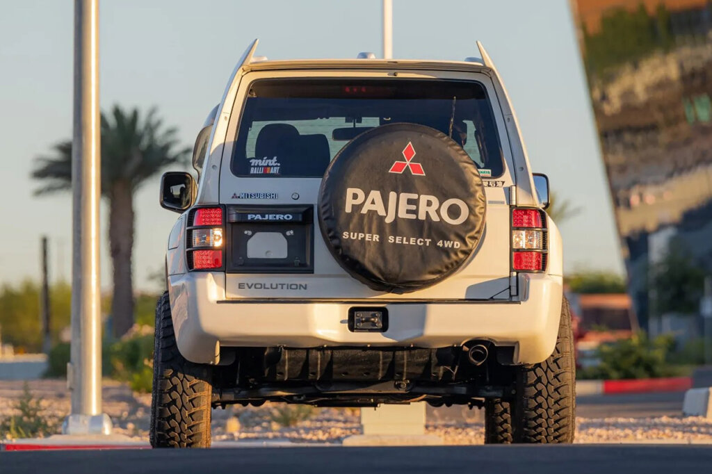 White Pajero with a tire cover on the rear door with blue sky in background