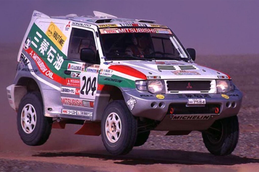 White Mitsubishi Pajero with japanese characters and colorful race livery airborne 