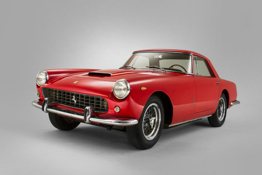 Red Ferrari 250 GT parked at an angle in an all white room