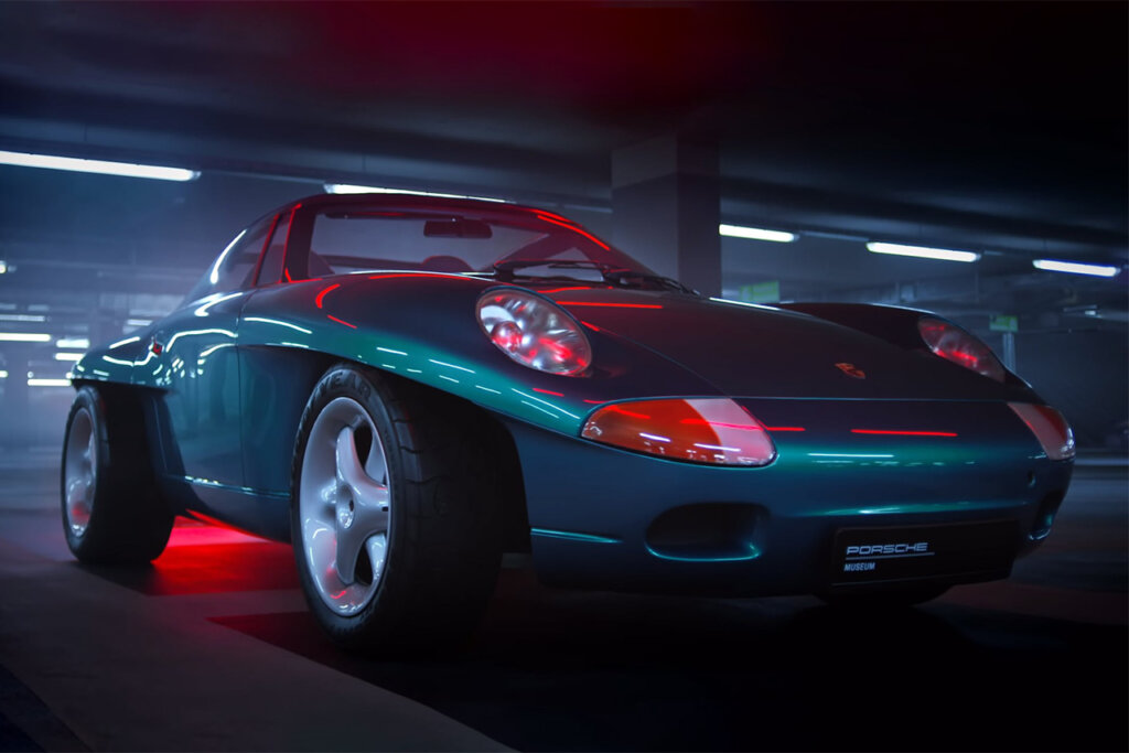 Green Porsche Panamericana concept car parked in dark garage with a red light casting a red glow on the car.