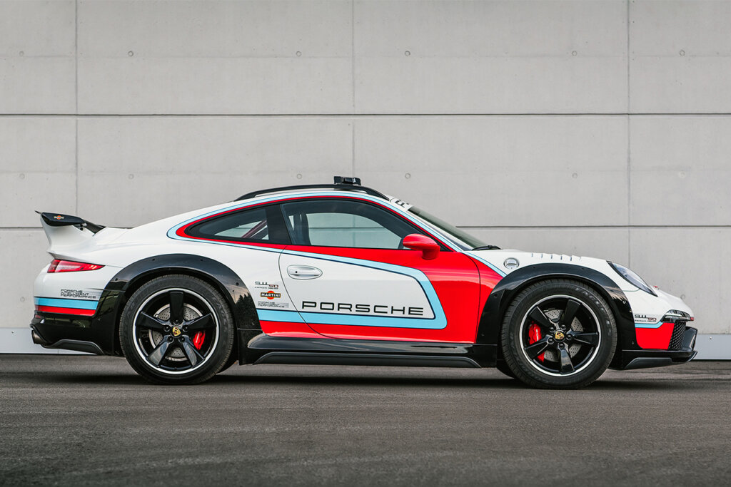 Martini Porsche Vision Safari concept car with large wheel and over fenders parked next to a brick wall.
