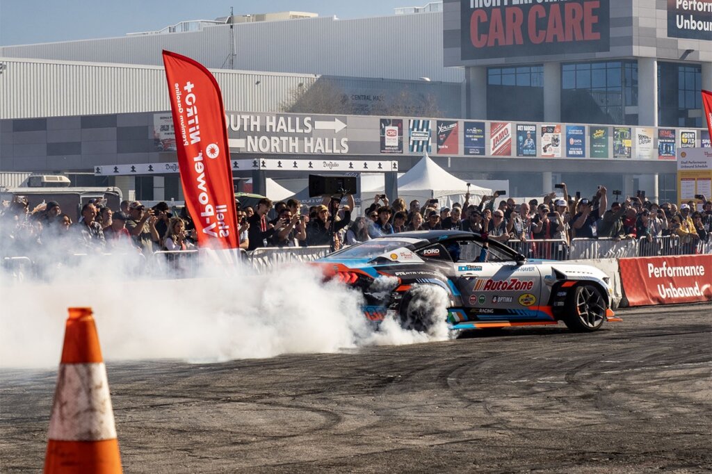 rear view of Silver james deane formula drift ford mustang drifting at sema