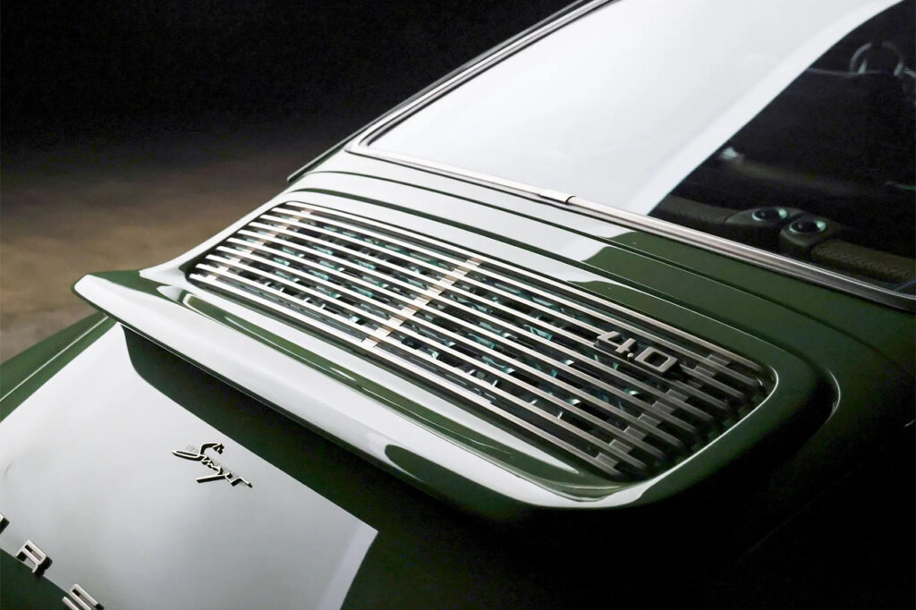Green Singer Porsche rear engine trunk cover with 4.0 badging pictured in a dark room.