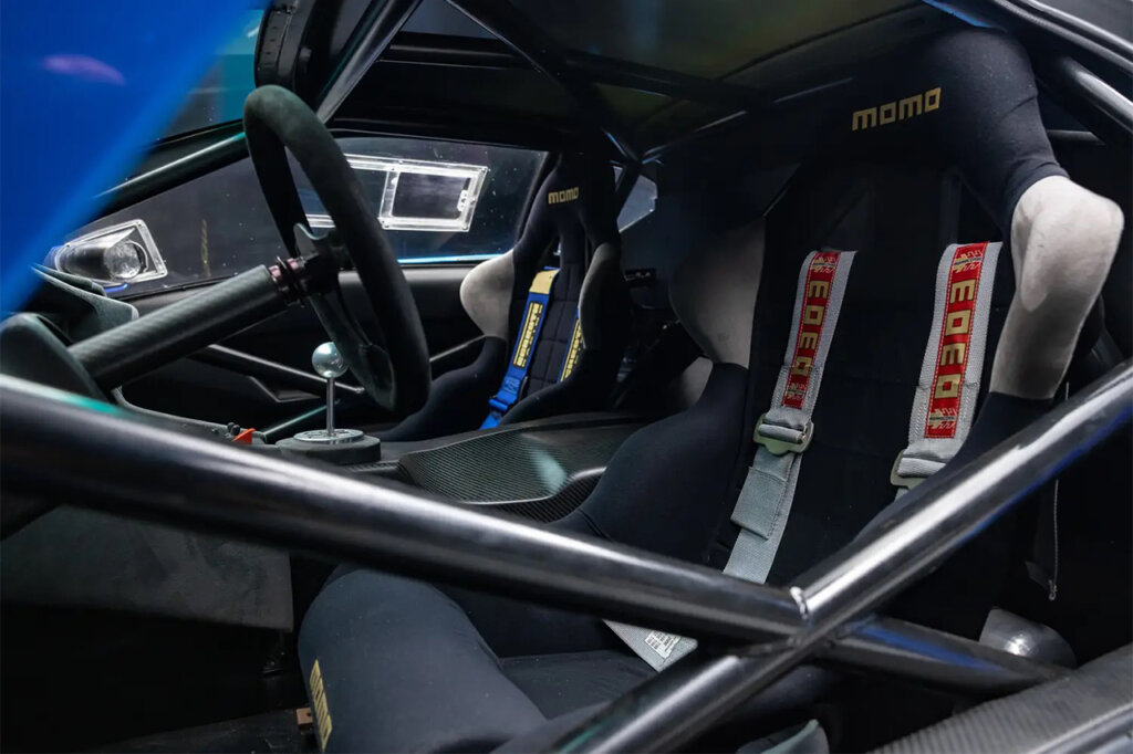 Racing bucket seats with MOMO safety harnesses and roll cage of a blue Diablo GTR.