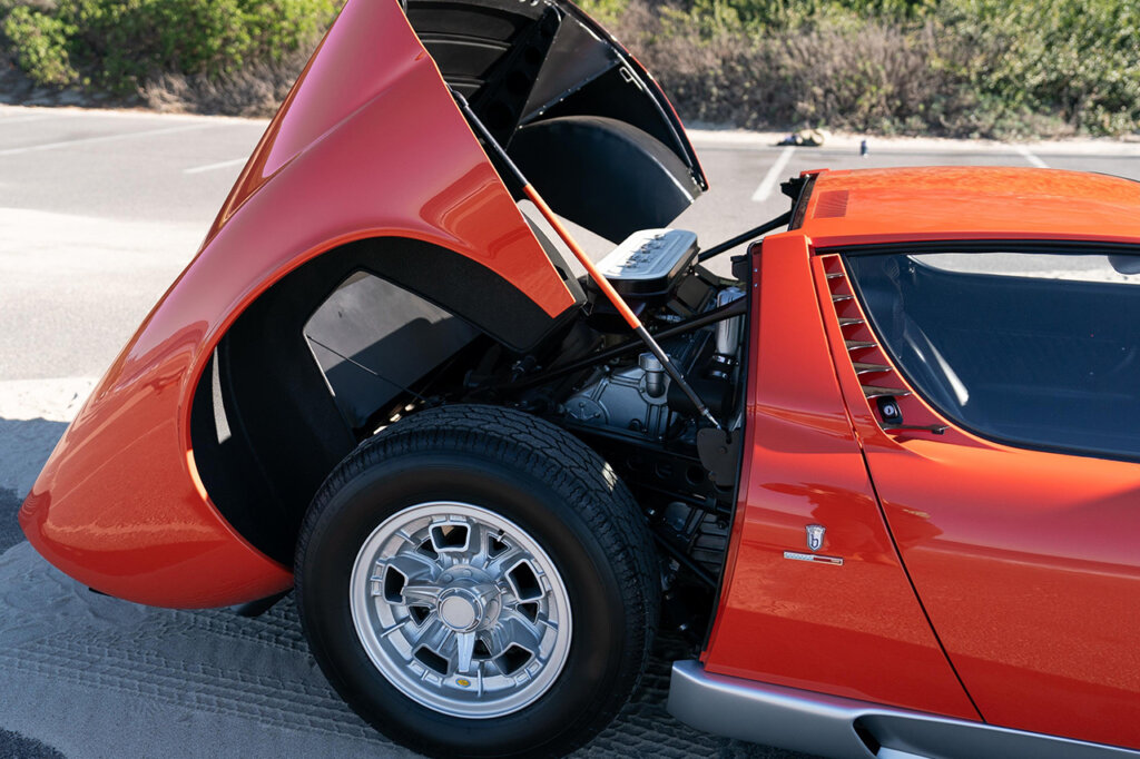 Rear mounted engine with rear trunk cover propped open of a red Lamborghini.
