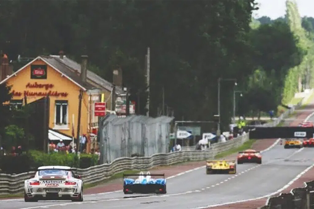 Color photo of many different race cars along the Mulsanne straight of the 24 hours of Le Mans race.
