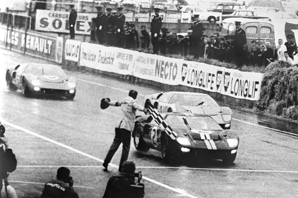 Black and white photo of Ford GT40 trio finishing 1,2,3 during 1966 24 hours of Le Mans race.
