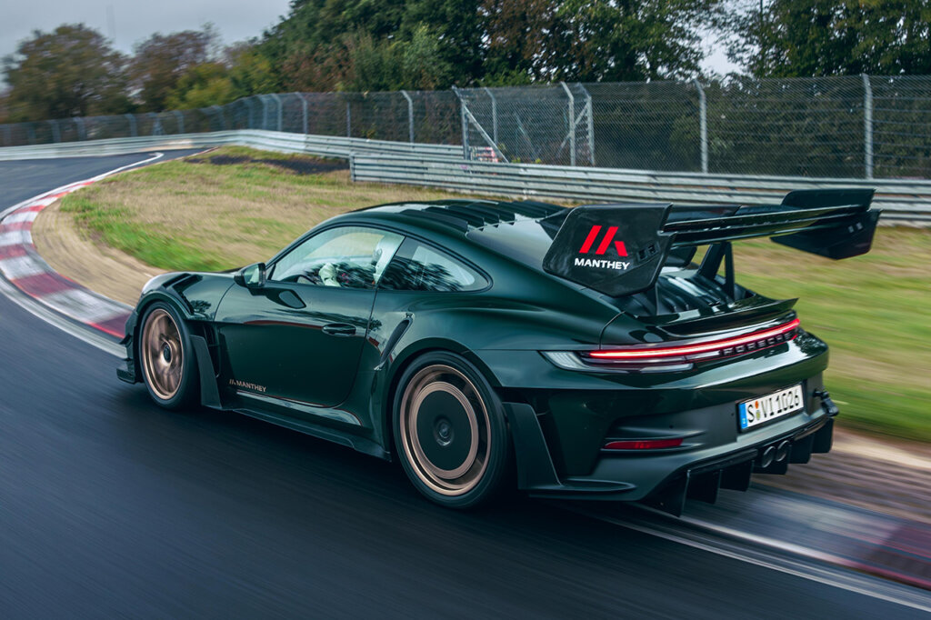 Green Porsche 911 992 with large fixed rear wing with Manthey Racing decal on the wing.