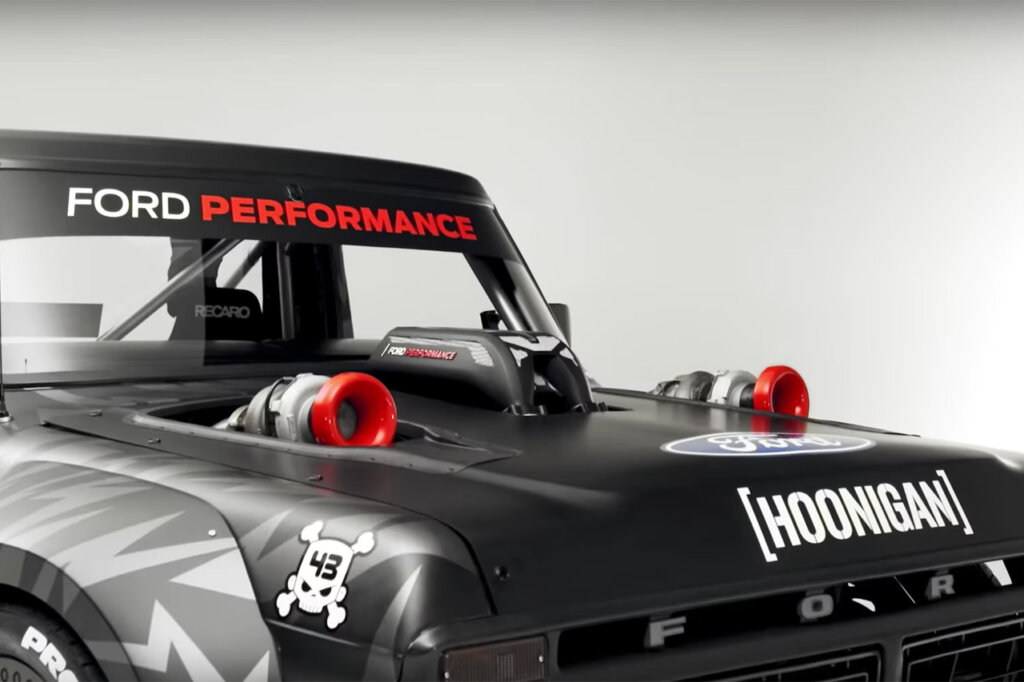 Black Hoonitruck hood with cutouts with twin turbo's with red inlets exposed and intake manifold with Hoonigan and Ford Performance decals with white background.
