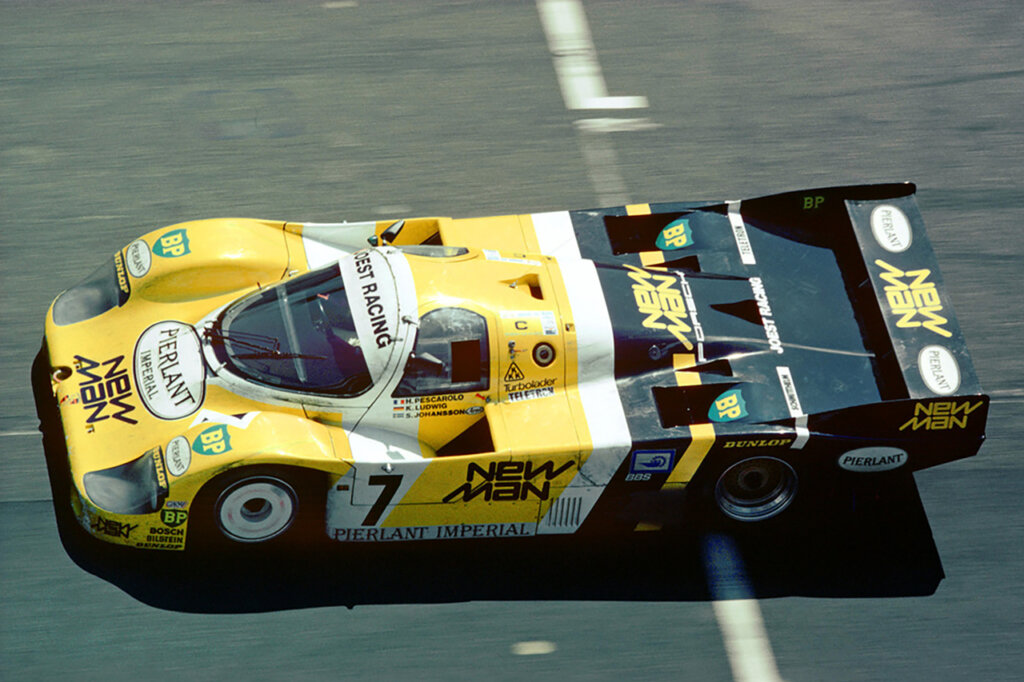 Yellow and Black 956B Joest Racing Porsche race car driving on a racetrack.