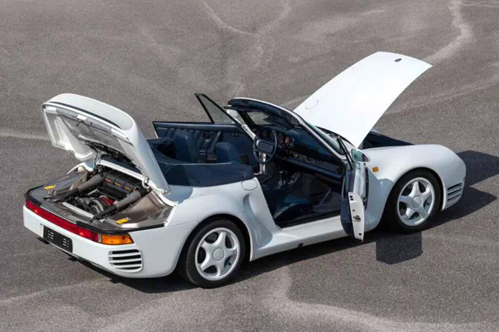 rear view of a white 1987 porsche 959 soft-top with hatches open