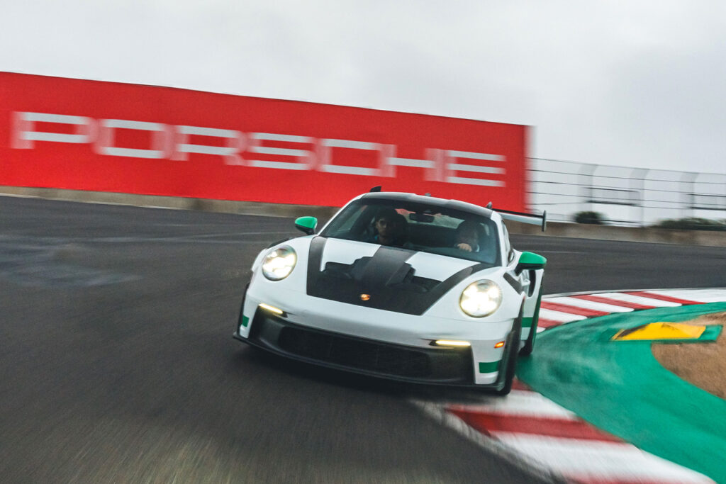 White and green Porsche 911 goes around a track