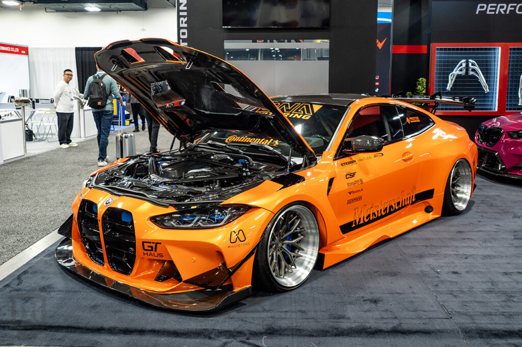 orange bmw m4 g82 in the dNA motoring booth 20329 at sema 2025