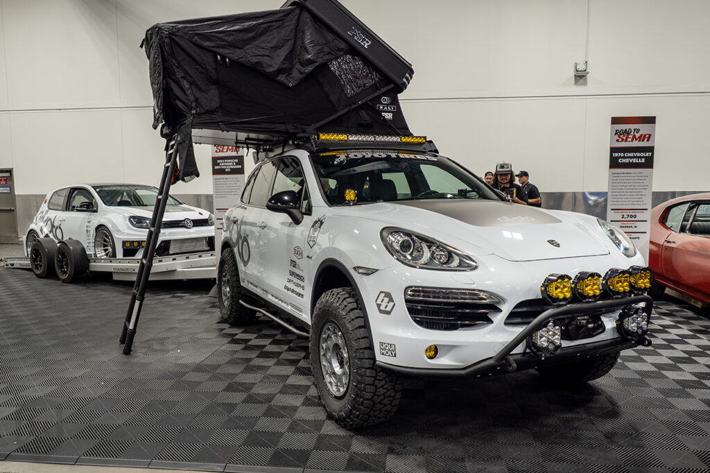 typicalstevenn white porsche cayenne hauling a white volkswagen golf in the road-to-sema booth #21651