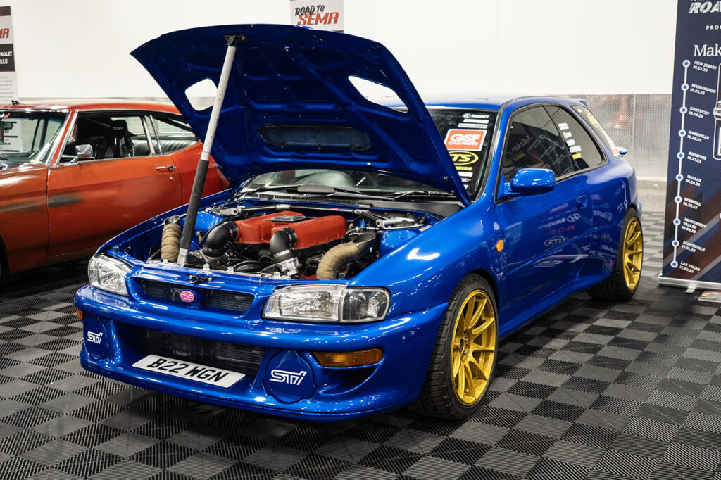blue haddzy subaru WRX STI GF8 Wagon with ferrari 360 v8 engine swap in road-tosema botth at sema 2025 central hall