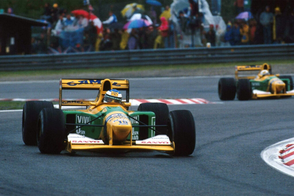 Yellow and green benetton b192-05 f1 race car on a race track